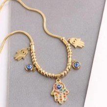 Collar dorado con dijes de mano de fatima y ojo turco